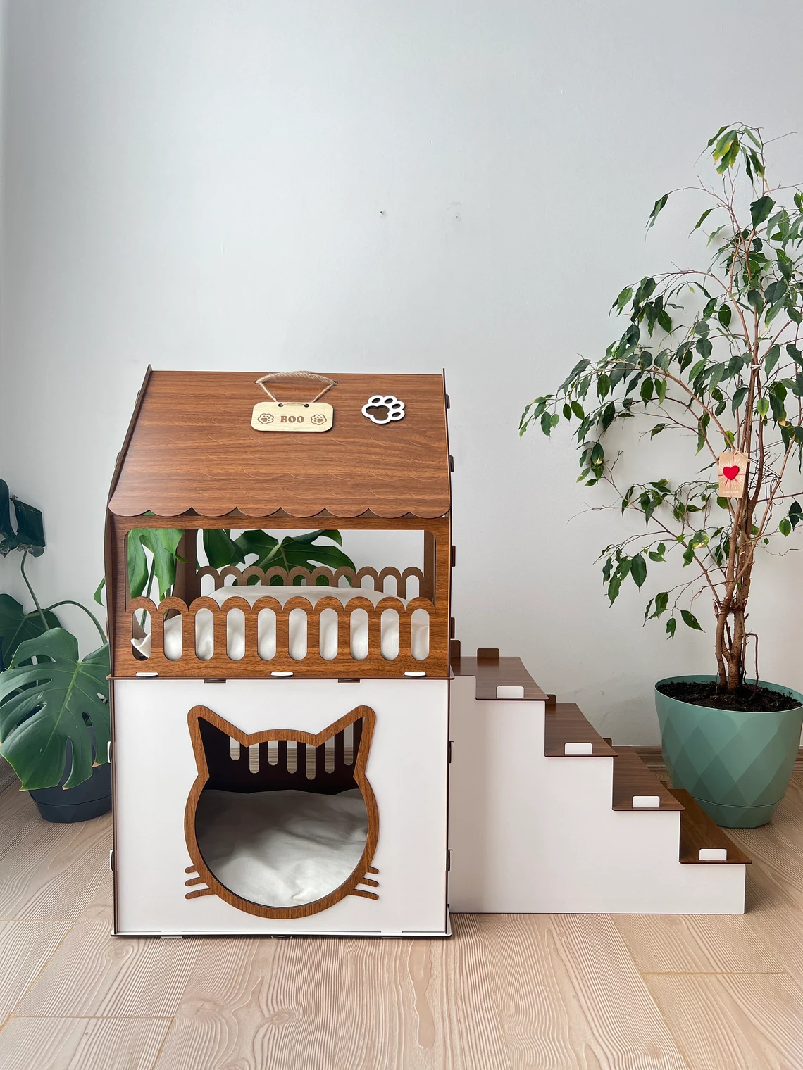 Side view of a large white and brown two-story modern wooden cat house, showcasing the roomy interior and contemporary design.