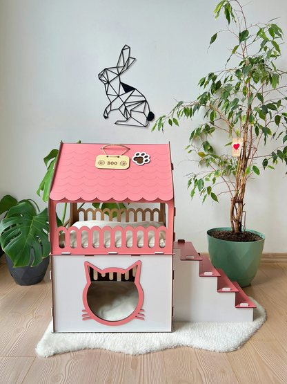 Side view of a large White and Pink two-story modern wooden cat house, showcasing the roomy interior and contemporary design.