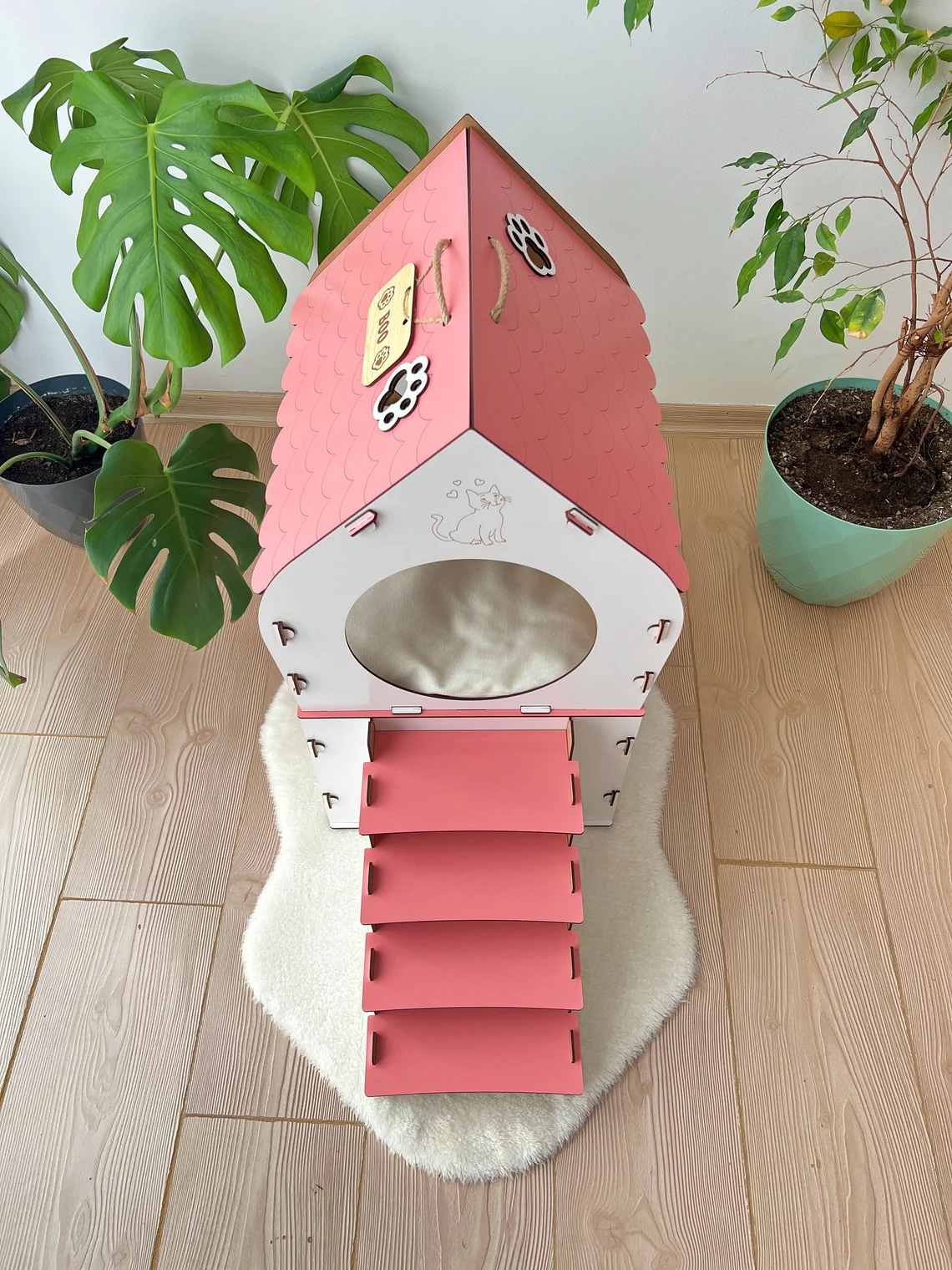 White and Pink medium two-story modern wooden cat house with a front view showing the two levels and entrance.